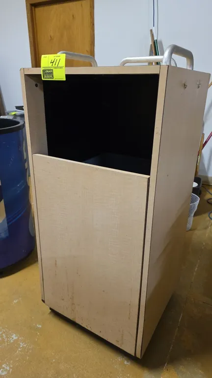 Portable trash receptacle enclosure. Features top tray rails, front access door, and interior poly waste container. 21" x 21" x 45.5"H.