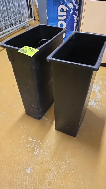 Poly slim trash cans. Features black plastic construction and space-saving slim profile design. Includes (2) cans. Note: One can has a cracked rim.