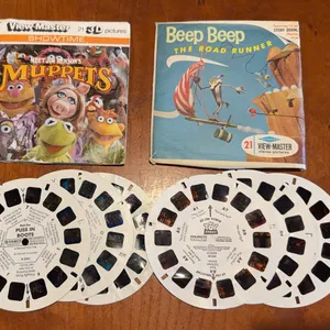 Four different view master reels. Muppets, Roadrunner, Puss in Boots, and Toy story.