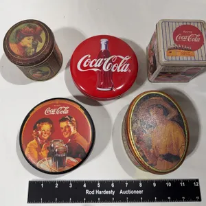 Collection of vintage-style Coca-Cola metal tins and containers