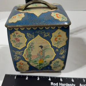 Vintage blue square metal tea canister with an oriental style floral design and handled lid.