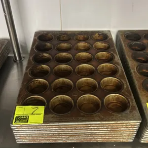 24-cup metal muffin pans. Features commercial metal construction arranged in a 4 x 6 cavity configuration with wire-reinforced rims.