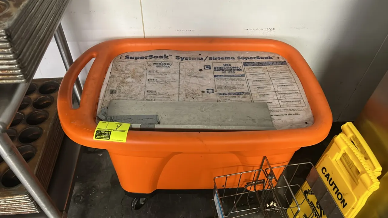 Ecolab SuperSoak System mobile soaking tank. Features orange polyethylene construction, integrated handle, lid with bilingual operating instructions,