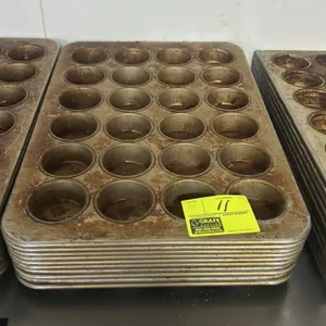 24-cup metal muffin pans. Commercial baking pans feature a 4 x 6 layout with 24 cups per pan and rolled rims.