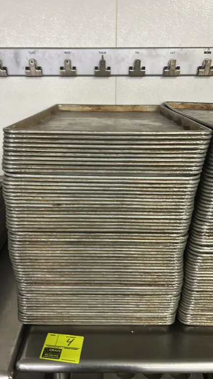 Metal full-size sheet pans. Features wire-reinforced rolled rim construction for commercial baking, roasting, and food service prep.