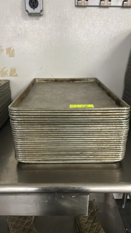 Metal full-size sheet pans. Features wire-reinforced rolled rims and nesting design. Stainless steel table and accessories not included.