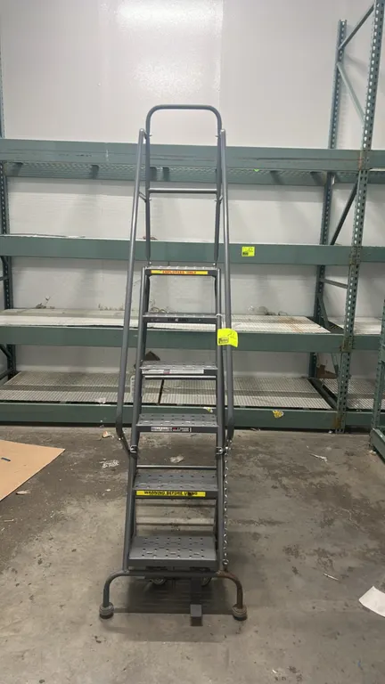 Tri-Arc 5' rolling safety ladder. Features 6-step steel construction with perforated slip-resistant treads, tubular handrails, top guardrail, and foot