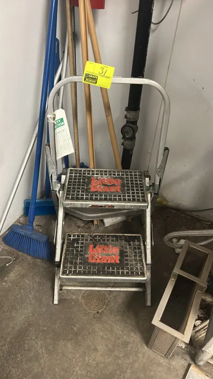 Little Giant 2-step folding ladder. Features aluminum construction, wide slip-resistant treads, and folding safety handrail. Background items not incl