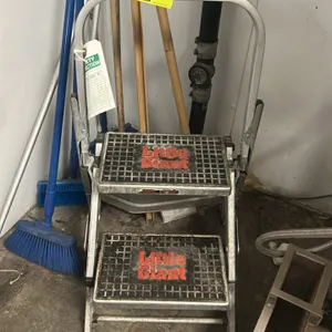 Little Giant 2-step folding ladder. Features aluminum construction, wide slip-resistant treads, and folding safety handrail. Background items not incl