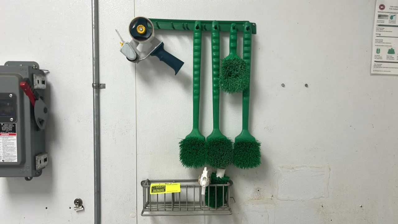 Wall-mounted organizing racks and cleaning accessories lot. Includes (1) green multi-hook hanging tool rack, (1) wire organizer basket, (4) green hand