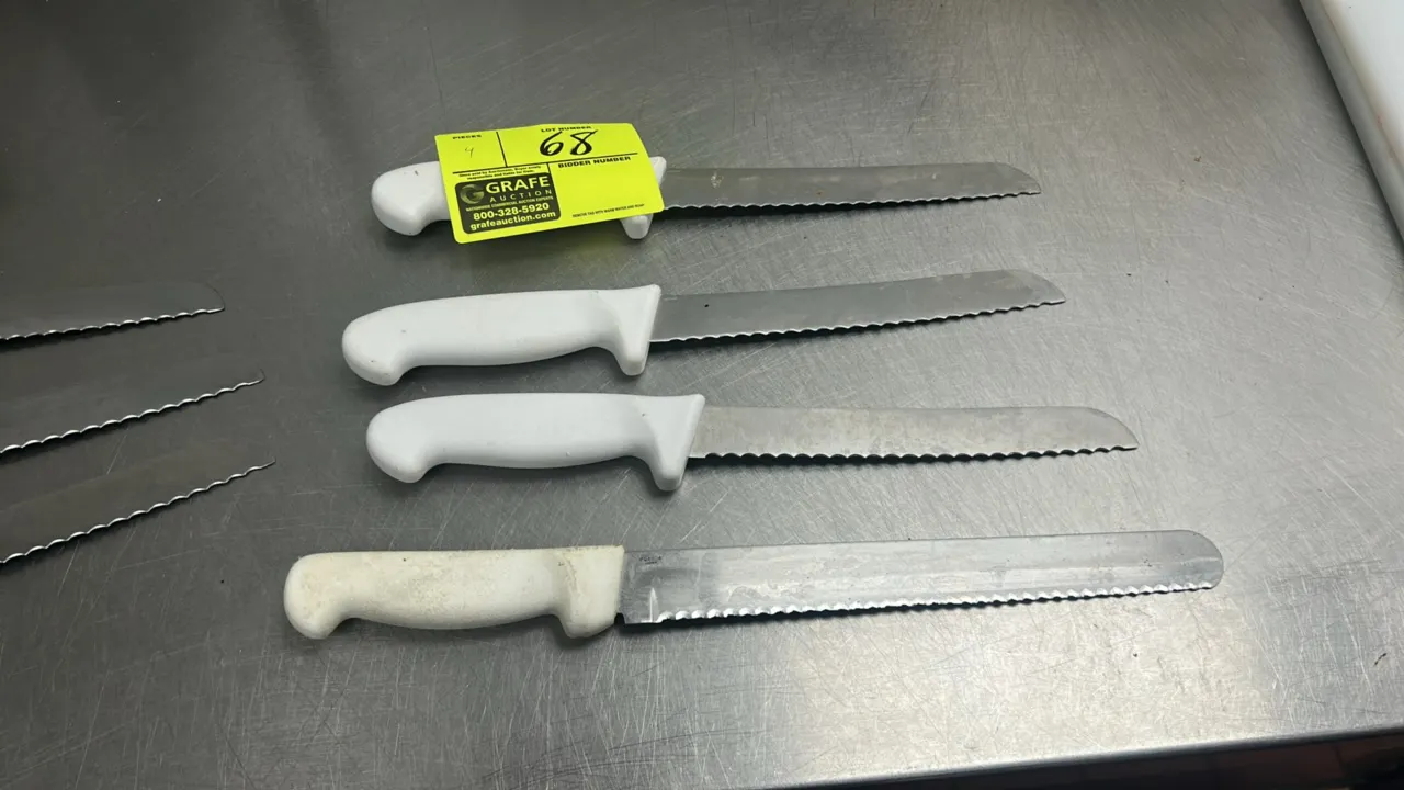 Stainless steel serrated kitchen knives. Features serrated stainless steel blades and white molded plastic handles.