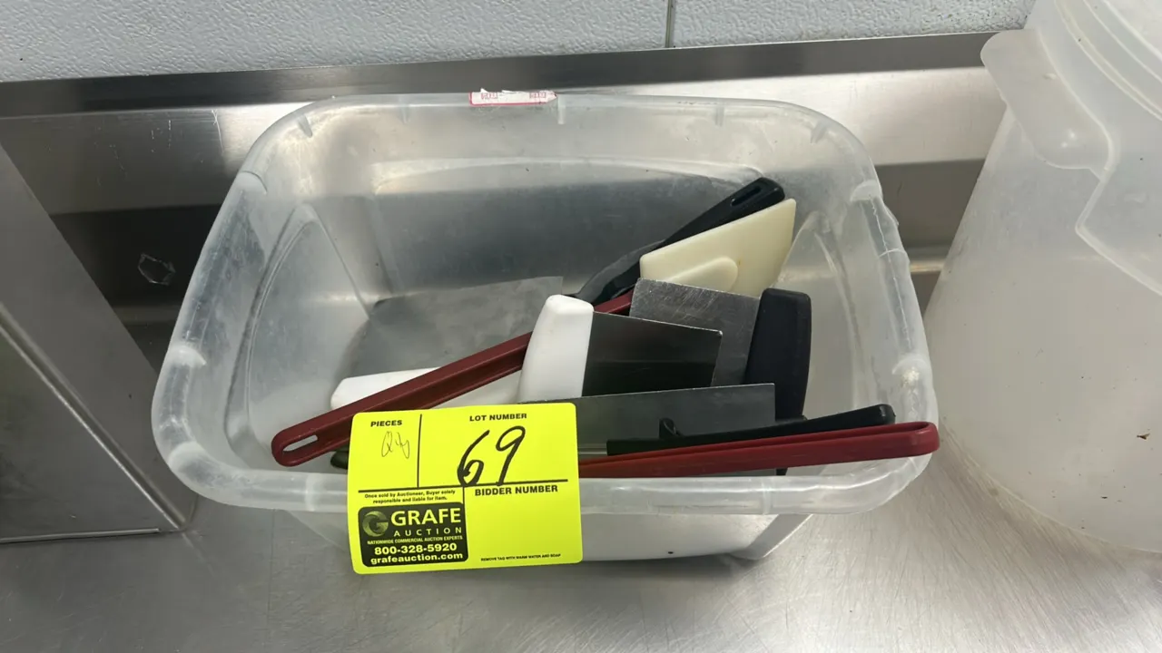 Assortment of commercial kitchen utensils and food storage containers. Includes stainless steel serving spoons, dough scrapers, tongs, high-temp spatu