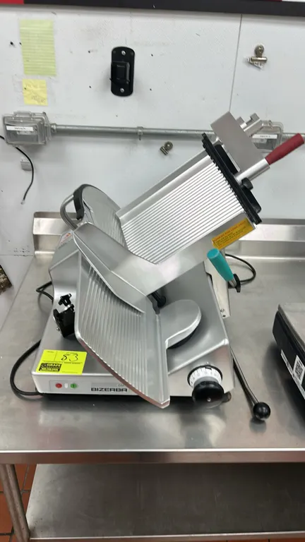 Bizerba GSP H commercial deli meat slicer. Features aluminum construction, gravity-feed carriage, product pusher, slice thickness adjustment knob, and