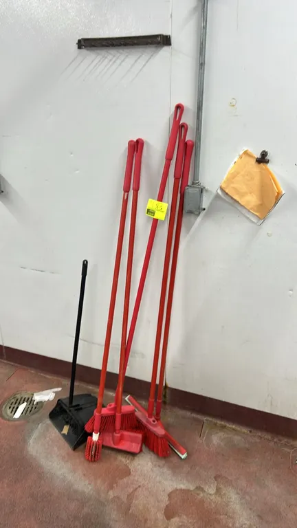 Assorted commercial cleaning tools. Includes upright lobby dustpan, brooms, floor squeegee, and long-handled utility brush.