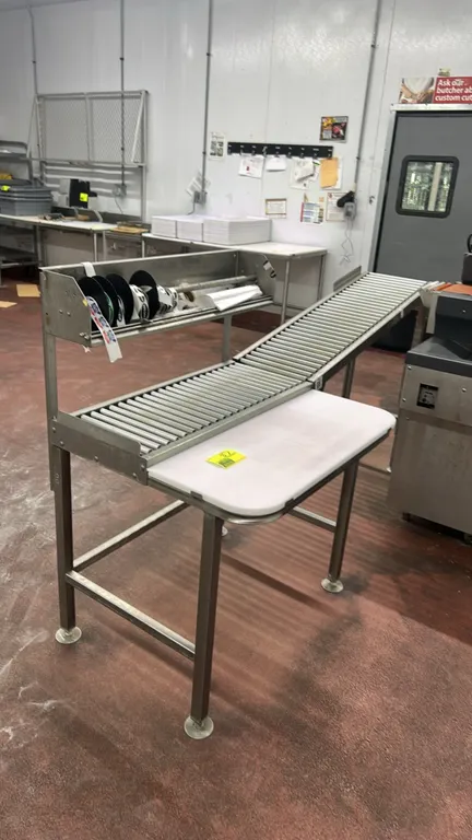 Hobart HRT5-3 stainless steel roller discharge table. Features gravity roller conveyor section, poly cutting board work surface, and upper label dispe