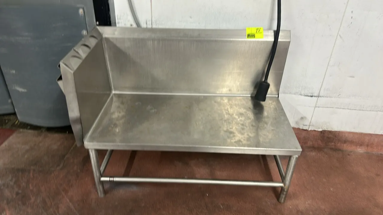 Stainless steel prep table. Features high rear backsplash and left side splash with (3) integrated dispensers. 4'L x 2'W. Mounted on tubular stainless