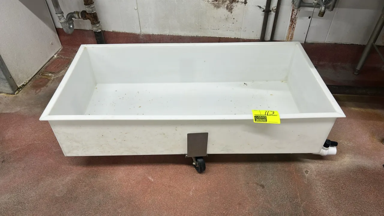 Poly portable drain bin. Features white polyethylene construction and side drain valve. 4' x 2'. Mounted on casters.