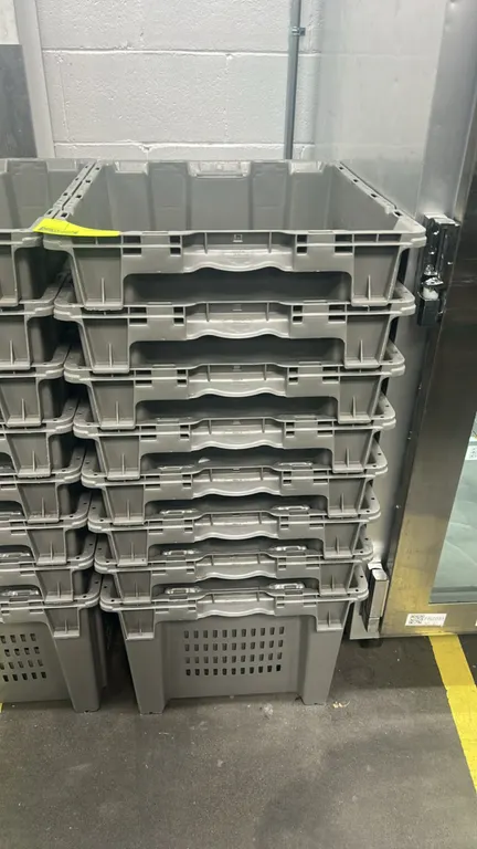 Poly crates. Features heavy-duty molded gray plastic construction, vented side walls, integrated handles, and stackable design. 24".