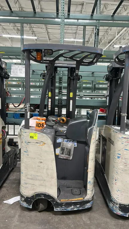 Crown RC5515-30 electric stand-up counterbalanced forklift. Features overhead guard, operator compartment, and forks. Includes Crown V-Force V-HFM ser