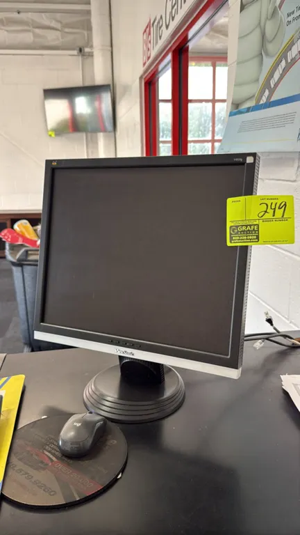 ViewSonic 19" computer monitor. Features a two-tone black and silver bezel with front-panel controls. Mounted on a circular desktop stand. Mouse and s