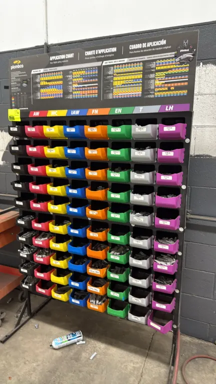 Plombco wheel weight bin rack with assorted wheel weights. Features a multi-tier organizer panel with color-coded plastic storage bins stocked with as