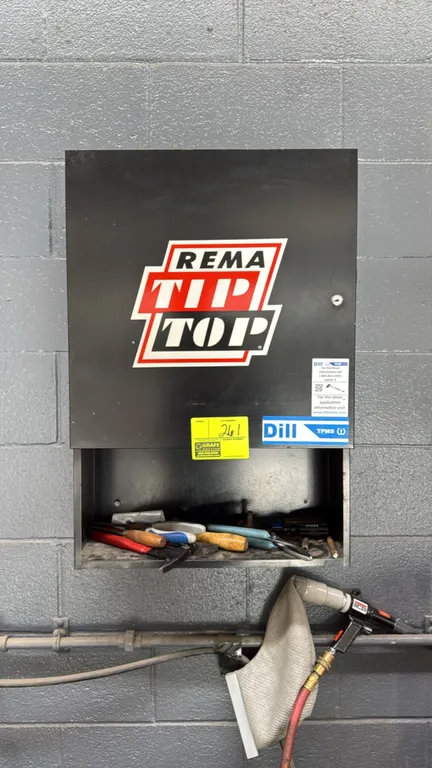 Rema Tip Top metal tool cabinet. Features single hinged door with interior shelving and open lower storage compartment. Includes assorted hand tools,