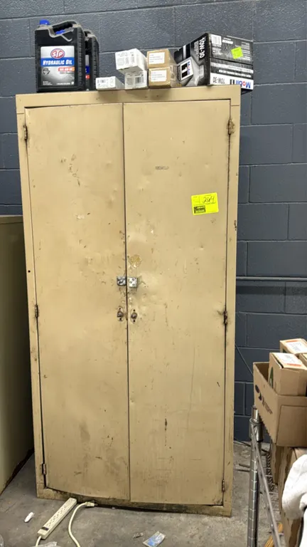 Metal 2-door storage cabinet with contents. Features double doors with padlock hasp and adjustable interior shelving. 3' x 6'. Includes contents shown