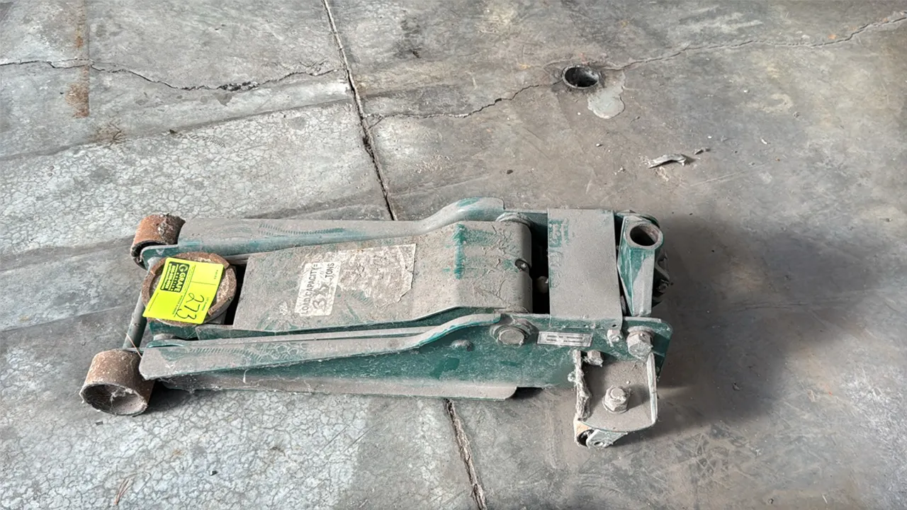 Hydraulic floor jack. 3 1/2-ton capacity. Features steel construction, front fixed wheels, and rear swivel casters. Note: Handle is missing.