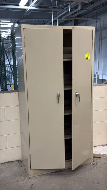 Metal 2-door storage cabinet. Features dual door handles and four interior shelves. 3' x 6'. Note: Cabinet shows dents on the doors, base, and back pa
