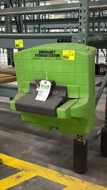 Fendall Pure Flow 1000 poly emergency eyewash station. Features green polyethylene housing and pull-down activation tray. Pallet racking not included.