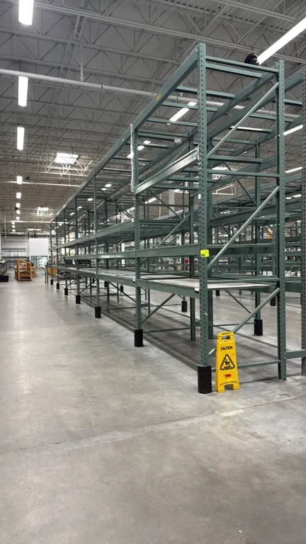Interlake warehouse pallet racking. Features teardrop punch pattern uprights, step beams, expanded metal wire decking, and green steel construction. I