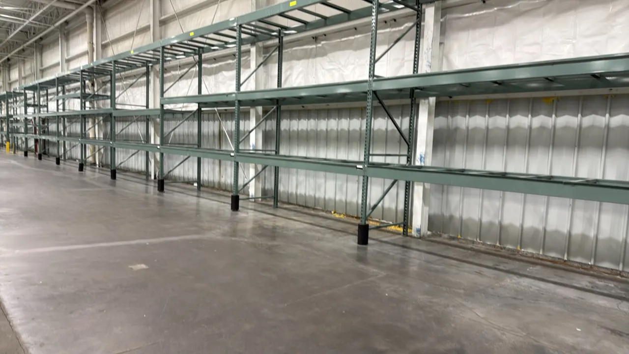 Interlake warehouse pallet racking. Features teardrop uprights, 3-tier beam levels, and drop-in pallet support crossbars. Finished in green. Dimension