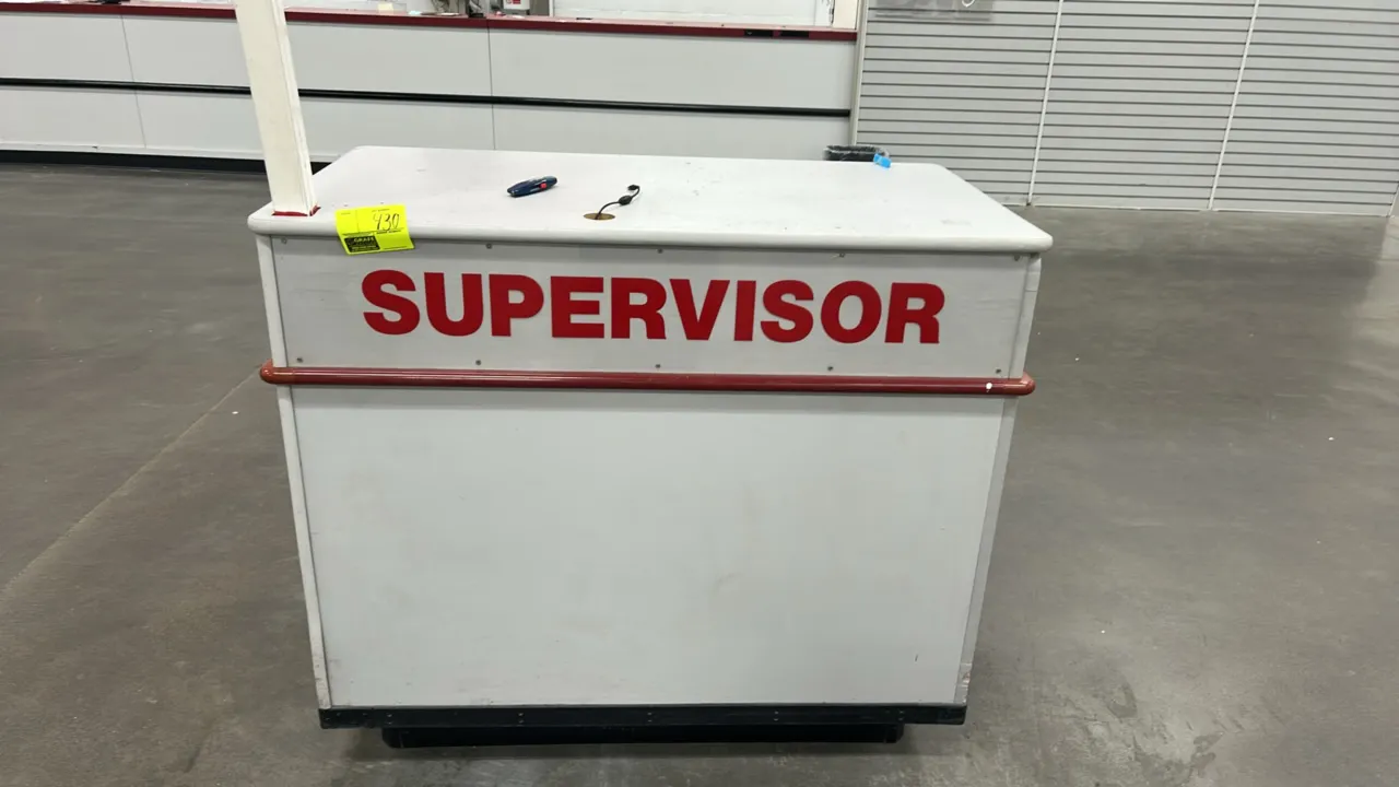 Laminate supervisor stand. Features white laminate construction with red 'SUPERVISOR' lettering, protective perimeter bumper trim, wire grommet, uprig