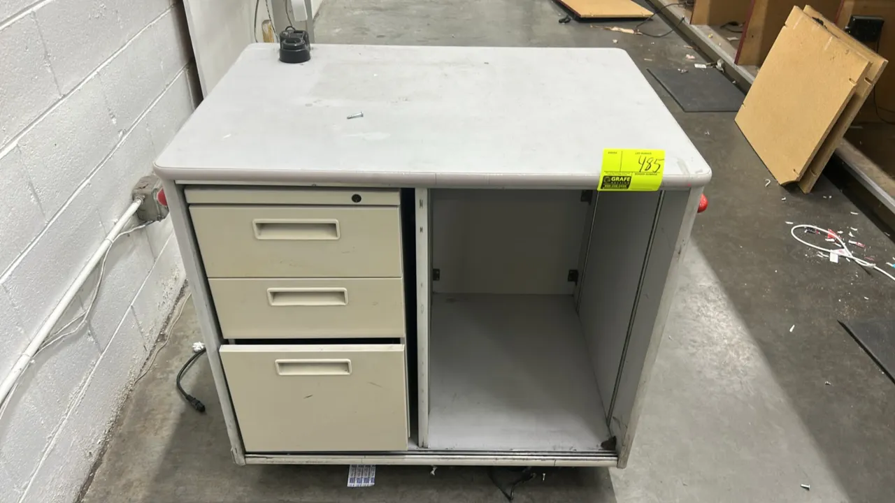 Laminate stand with metal 3-drawer filing cabinet. Features laminate work surface, 3-drawer metal file pedestal, open storage compartment, and protect