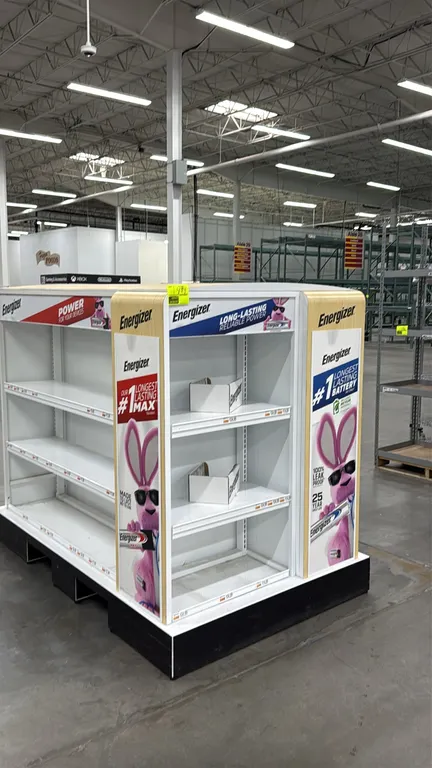 Metal island merchandiser display rack. Features Energizer branded graphics, multi-tier adjustable shelving with integrated price tag channels, and cu