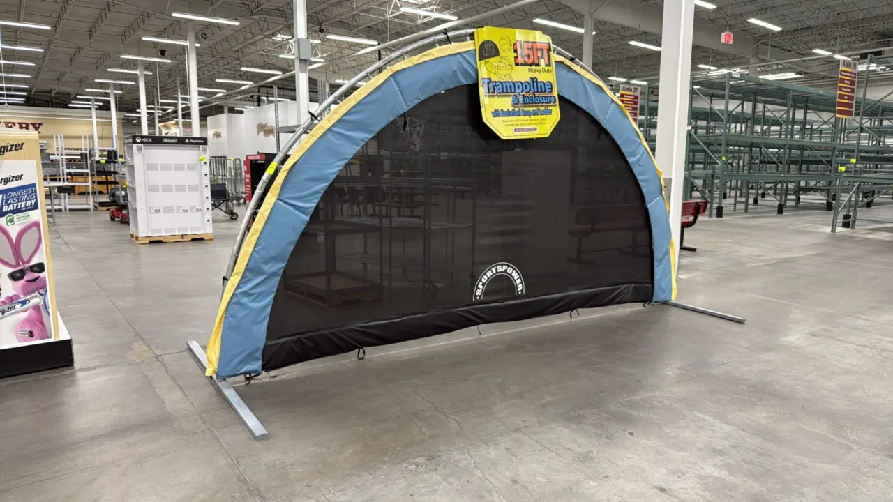 Sportspower trampoline retail store display. Features semi-circular arched frame with spring-attached netting and padding, and promotional signage for