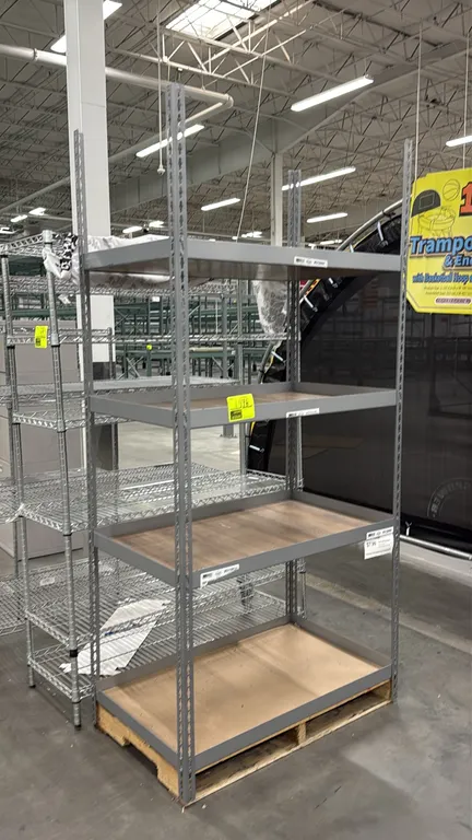 Metal shelving rack. Features a gray steel frame with rivet keyhole uprights and 4 tiers with wood laminate decking. 40" x 24" x 85". Note: Pallet not