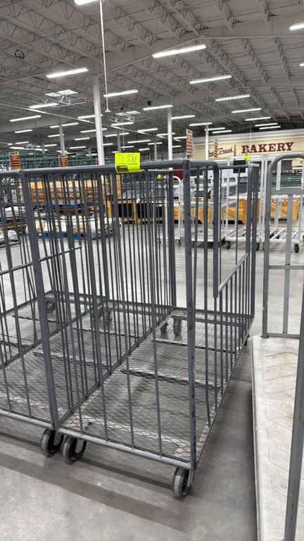 Metal trash cart. Features steel frame construction, vertical bar sides, expanded metal mesh deck, and cutout side opening. 6'. Mounted on casters. Ad