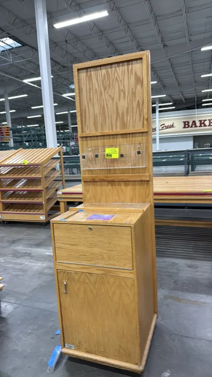 Wood display kiosk. Features oak woodgrain laminate construction, upper sign display panel, clear acrylic literature holder, countertop slot, upper lo
