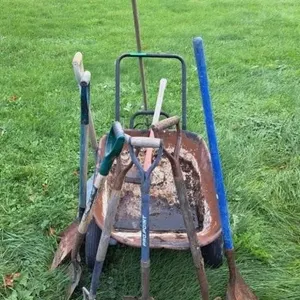 Wheel barrow with garden tools: shovels, axe,