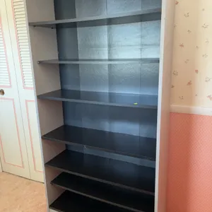 freestanding wooden bookcase featuring a light-colored outer frame and black horizontal shelves