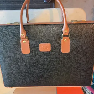 vintage Geoffrey Beene hard-shell attaché briefcase with a black pebbled texture, tan leather trim,