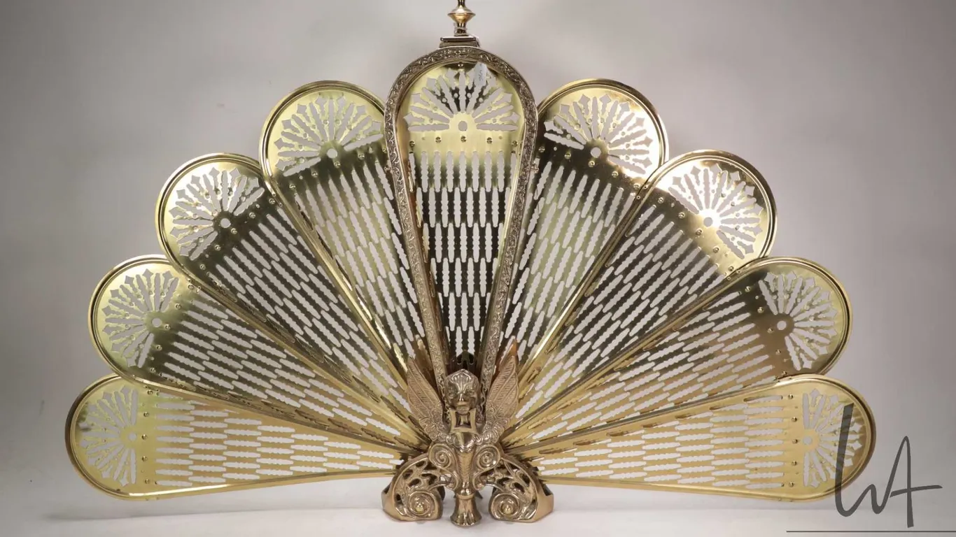 Vintage brass peacock tail folding fireplace screen with winged gargoyle base, measures 38" across a
