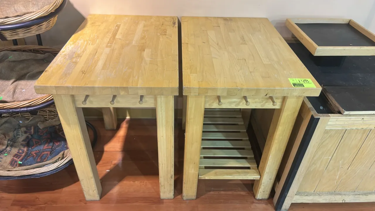 Wooden bakery tables. Features butcher block tops, solid wood frame and legs, and side hanging pegs. Includes one table with a lower slatted shelf and