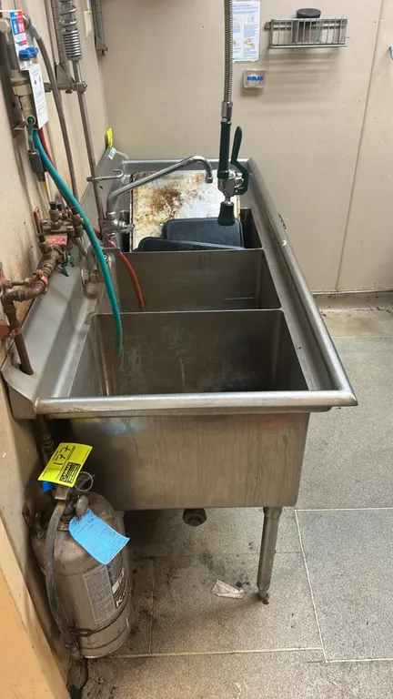 Stainless steel 3-compartment sink. Features right drainboard, splash-mount pre-rinse faucet assembly with spring-action gooseneck spray valve, 3 leve
