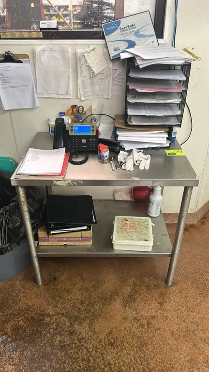 Stainless steel work table. Features a flat top and lower undershelf. 3' x 2'. Mounted on tubular legs. Contents not included.