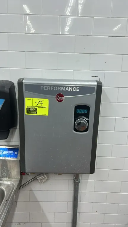 Rheem Performance electric tankless water heater. Features self-modulating technology, digital temperature display, and rotary control dial. Wall-moun
