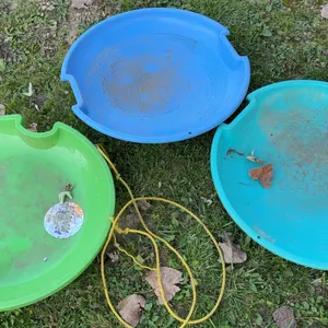 Three 26-inch plastic flying saucer snow sleds