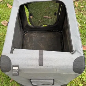 Collapsible gray fabric soft pet crate for travel and home use.