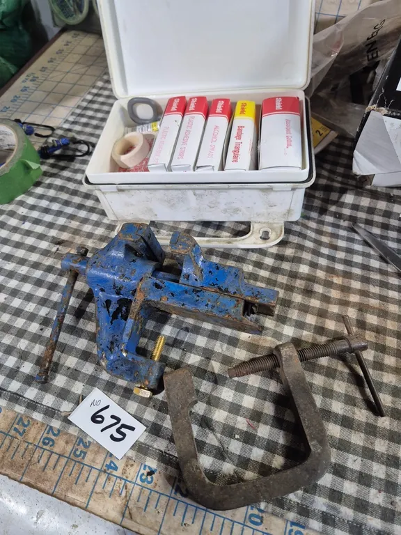 Small vice, first aid kit and C clamp.